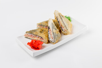 Sandwich sushi roll with breaded ham, rice and cheese. White plate on a plain background.