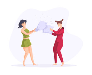 Smiling female friends playing pillow fight having fun together enjoying friendship