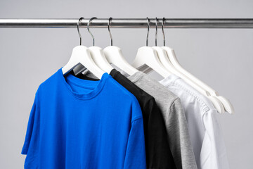 Obraz premium Clothes hang on clothing rack over white background.