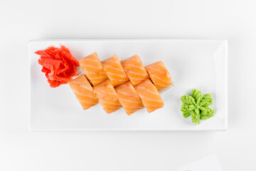 Sushi roll "Philadelphia" with fish. Wasabi and ginger. White plate and background.
