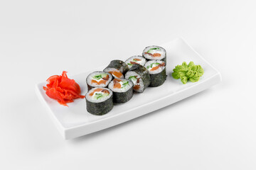 Sushi roll Syake Maki with red fish, cucumber and rice in nori seaweed. Plate on a white background.