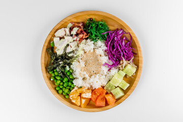 Poke with rice, peas, chicken, cucumber, tangerines, tomatoes and nori seaweed. Wooden plate on a white background.
