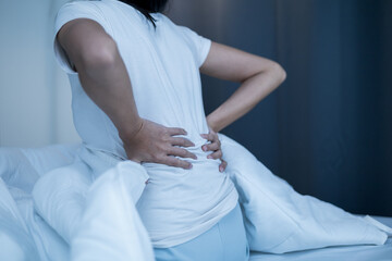 Waking up with a backache. Woman can't fall asleep moving restless on bed. Young woman having sleep troubles trying can not sleep.