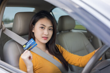 Young beautiful asian women getting new car. Hand holding credit card payment. Car owner paying...