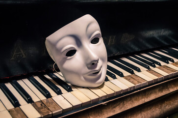 White mask on the keys of an ancient piano.