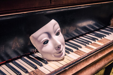 White mask on the keys of an ancient piano.