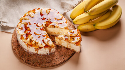 Food banner. Banana cheesecake with caramel on a beige background. Homemade delicious pastries....