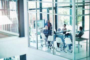 Giving it to them straight. High angle shot of an attractive young businesswoman giving a presentation in the boardroom.