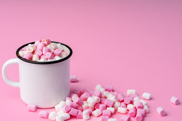 Fototapeta na wymiar Cup of hot cocoa with marshmallows on pink background