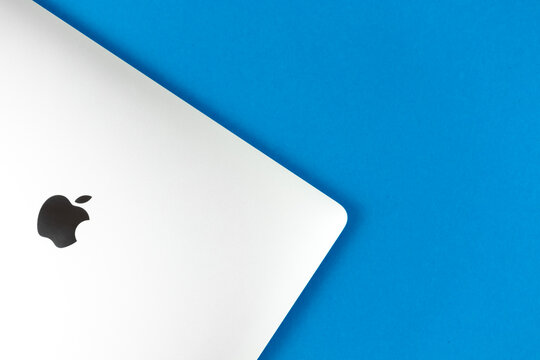 Apple Macbook on bright blue table background. Business and office concept, top view, flat lay photo
