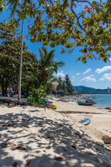 Colourful sunset over Patong Beach in Phuket Thailand with boat in foreground