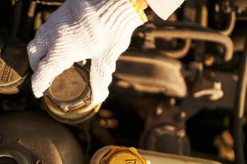 Faceless person checking fluids in car