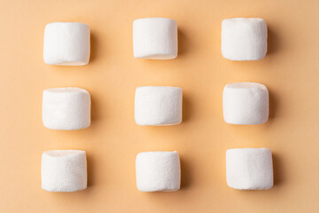 Fluffy marshmallows on beige studio background, top view