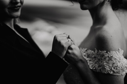 Pareja de chicas reci&eacute;n casadas cogi&eacute;ndose de la mano con el anillo de pedida