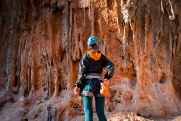 Girl is climbing on the red rocks, leads an active lifestyle.