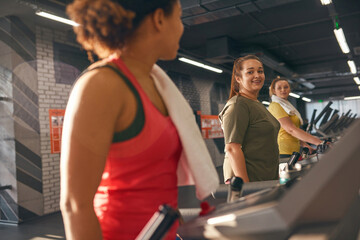 Multiracial girls running on treadmill in gym