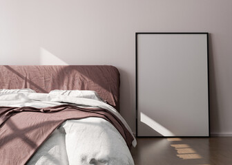 Empty vertical picture frame standing on wooden floor in modern bedroom. Mock up interior in minimalist, contemporary style. Free space for picture or poster. Bed, sunlight. 3D rendering.