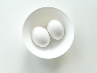 White egg in the white bowl isolated on white background. Protein for eating.
