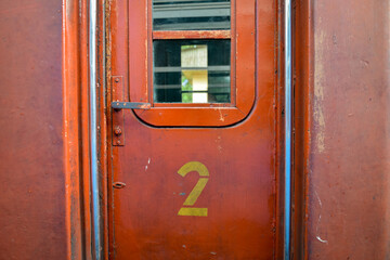 vielle porte rouge  d'un wagon de train avec le chiffre deux