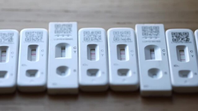 Row of positive Covid-19 antigen rapid home lateral flow tests.  Zoom out.