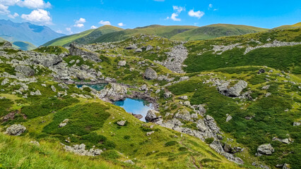 Fototapeta na wymiar Colorful Abudelauri mountain lakes and hills in the Greater Caucasus Mountain Range in Georgia,Kazbegi Region. Trekking and outdoor travel in mountainous areas.Reflection in the lake