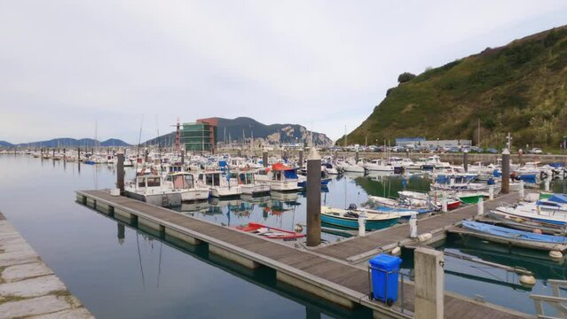 4k video of ships and boats docked at the Laredo Marina reflecting the berths and walkways in the water and the La Marina building in the background