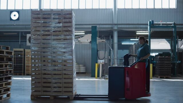 Female driving warehouse truck moving package pallets operating transport