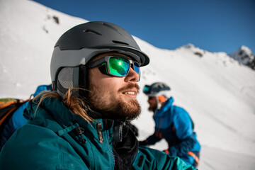Fototapeta na wymiar selective focus on the face of a bearded man in sunglasses and a ski helmet