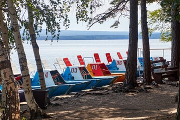 Fototapeta na wymiar recreational catamarans on the summer lake shore
