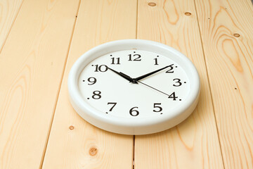 round wall clock lie on a wooden background
