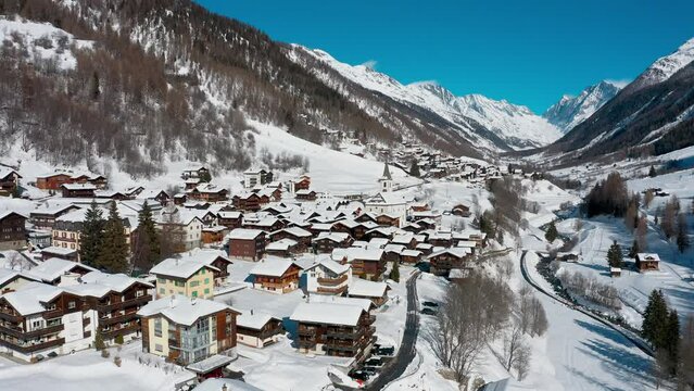 Village de montagne dans une vall&eacute;e enneig&eacute;e des Alpes suisses. Vues a&eacute;riennes.