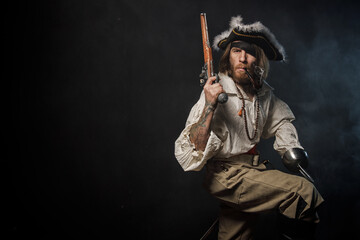 Naklejka premium Portrait of pirate filibuster sea robber in suit with guns. Concept photo