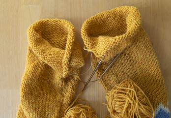 Icelandic wool knitted lopapeysa sweater sleeves in progress, magic loop technique with yellow yarn...