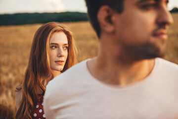 Fototapeta premium Portrait of a couple walking through the wheat field and exploring new places. Close up portrait of a man and woman.