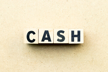 Obraz premium Alphabet letter block in word cash on wood background