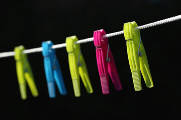 A close-up of colorful clothes pegs on a washing line
