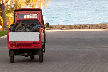compact small car on the city street, municipal garbage truck