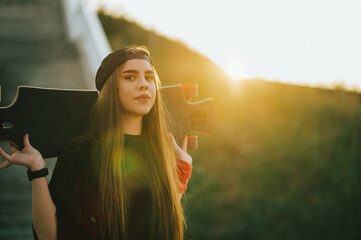 Young woman holding her longboard and standing on the bridge © Zamrznuti tonovi