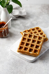 Waffles empty on white board with chocolate paste and vase