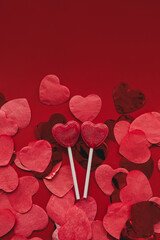 Heart shaped confetti on red background. Valentine's Day celebration.