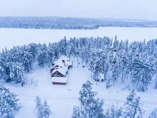Keuken spatwand met foto Torassieppi Reindeer Farm Accommodation showing cabins in the woods inside the arctic circle in Finnish Lapland, Finland drone © Matthew