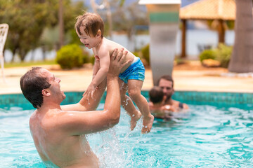 father playing with his son in the pool, narrow focus