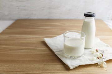 Milk bottle and glass of milk on wooden table