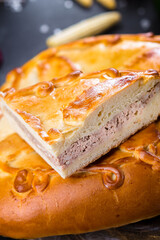 on a wooden cutting kitchen board, homemade pie with different fillings of meat or bacon, cheese...