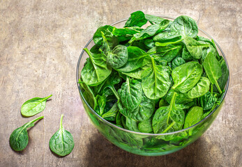  Spinach leaves in a bowl  on wooden  table. Fresh Spinach Closeup. Top view