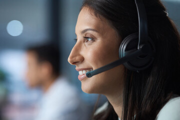 The best in the customer care business. Shot of a young woman using a headset in a modern office.