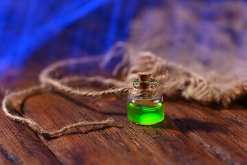 Green glowing liquid in a small bottle, concept photo in the style of fantastic magic.