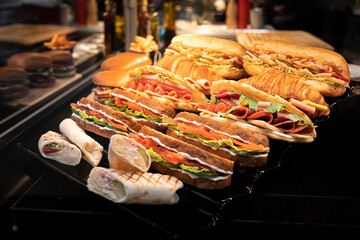 Lots of different sandwiches on the counter in store.