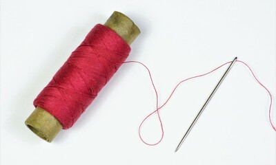 The sewing needle is a pointed tool and a red thread threaded into the eye of the needle. Designed...
