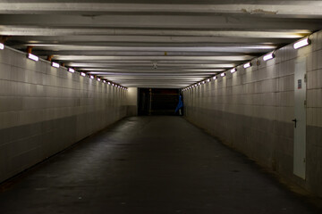 Underground pedestrian crossing. A long concrete tunnel with lanterns in the city underground....